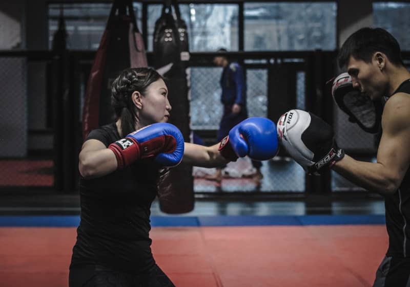 A man and a woman boxing in a gym